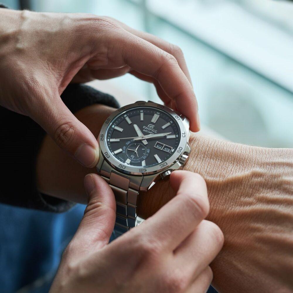 ręka ustawiająca wskazówki zegarka